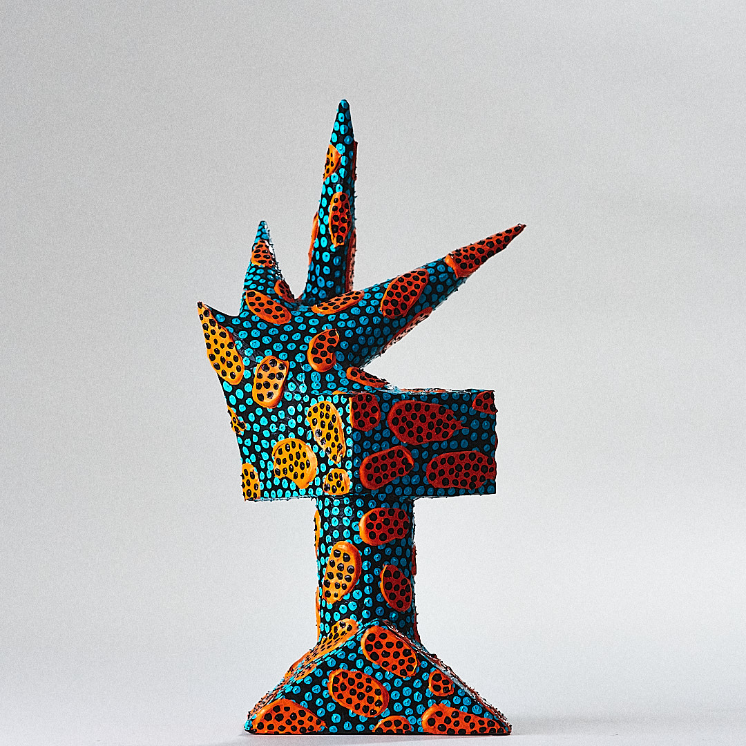 Turquoise dots and orange rounded motifs cover a black horned sculpture.